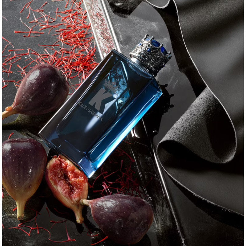 Blue perfume bottle with figs and saffron on a dark surface