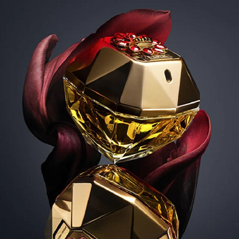 Gold perfume bottle with a red flower on a dark background