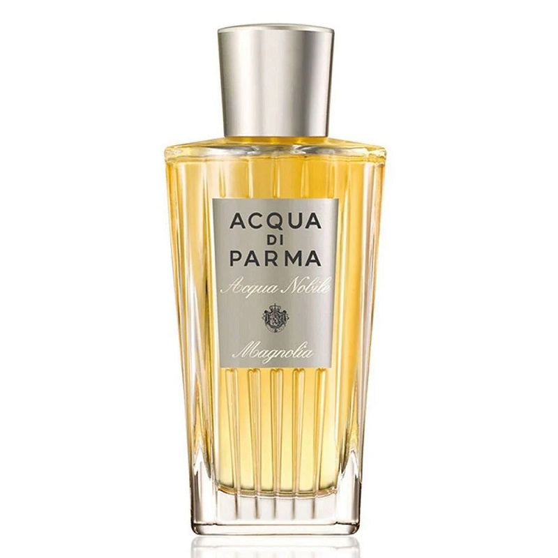 A clear glass bottle of Acqua Nobile Magnolia eau de toilette by Acqua Di Parma with a yellow-tinted liquid inside and a silver cap.