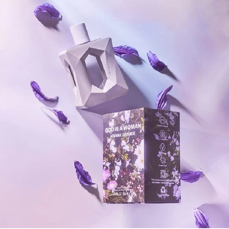 Perfume bottle and packaging with purple flowers on a light purple background