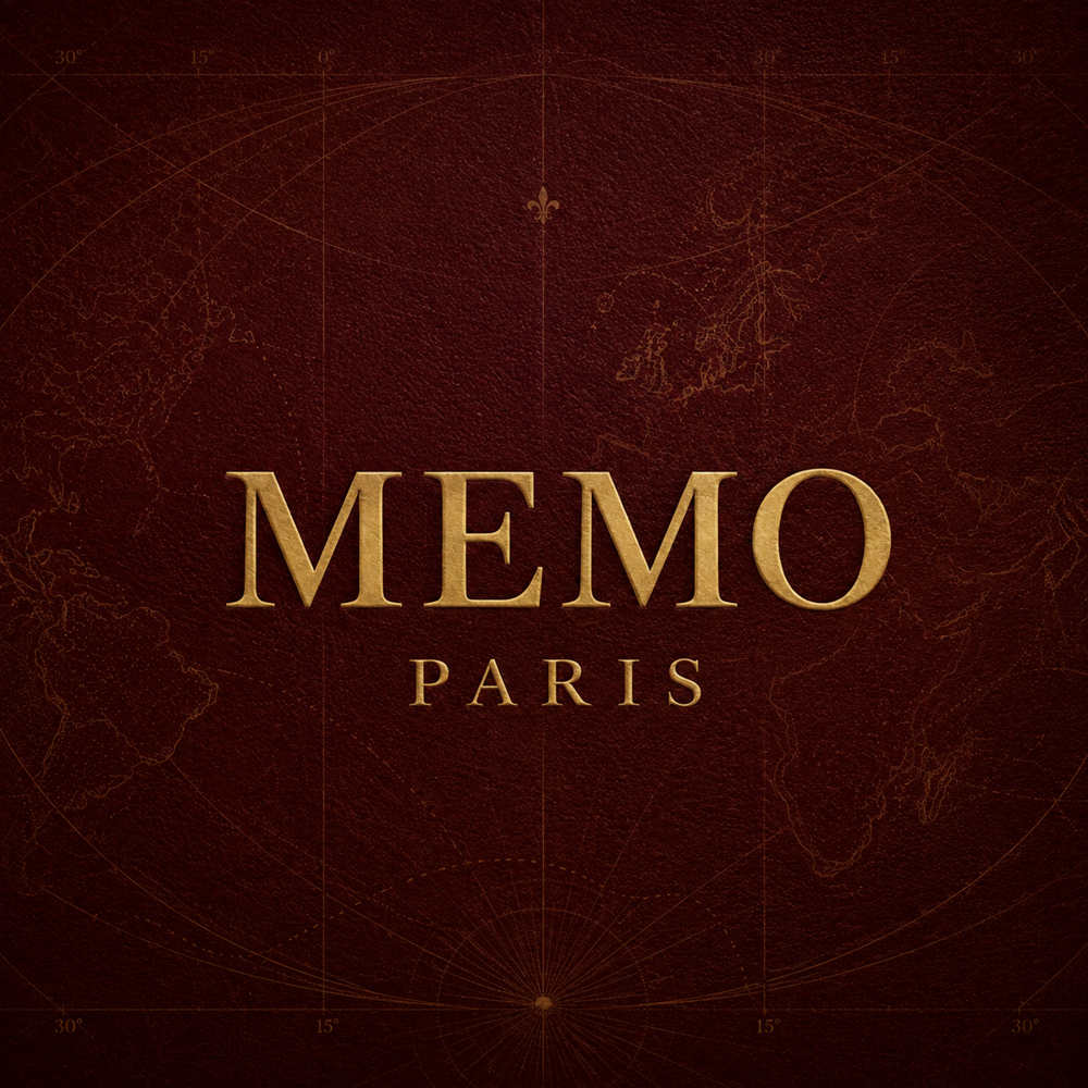 Gold Memo Paris logo on a deep oxblood red travel inspired textured background