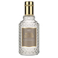 A clear glass bottle with a gold-colored label and a golden cap, labeled 4711 Acqua Colonia Myrrh + Kumquat.