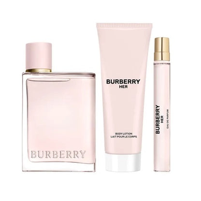 A 3-piece gift set by Burberry, including a bottle of 'Burberry Her' eau de parfum, a body lotion tube, and a perfume spray bottle, all in a matching pink packaging.