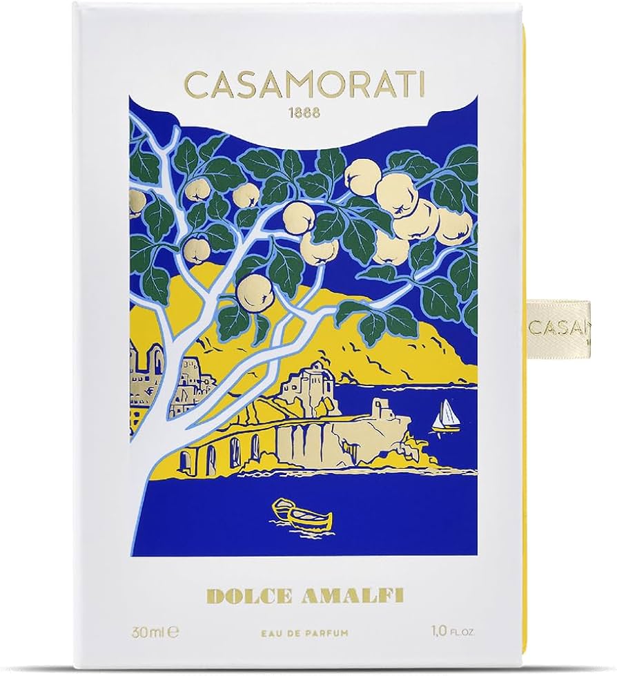 A product image featuring the Casamorati Dolce Amalfi Eau De Parfum by Xerjoff. The packaging is predominantly white with a blue background and an illustration of a tree, a house, and the ocean.