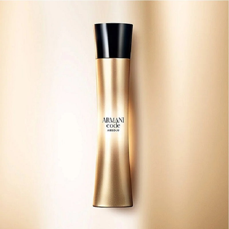 Gold and black Armani Code Absolu perfume bottle on a beige background
