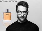 Man wearing glasses with a Hugo Boss perfume bottle on a gray background