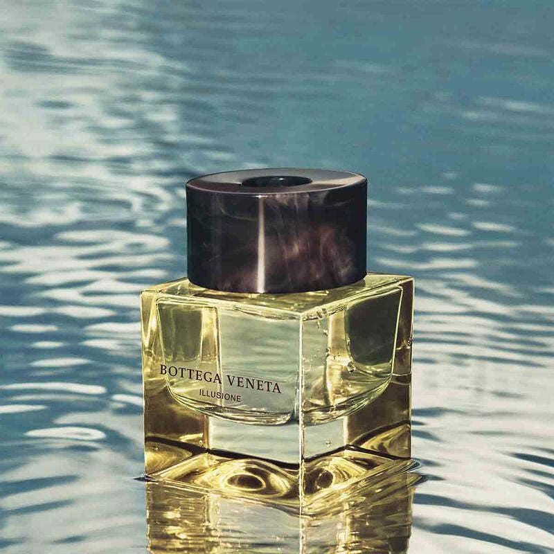 Bottega Veneta Illusione perfume bottle on a reflective water surface