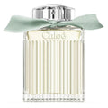 A bottle of Chloé Naturelle Eau de Parfum with a clear, light green liquid visible and a mint green ribbon around the top.