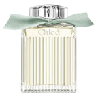 A bottle of Chloé Naturelle Eau de Parfum with a clear, light green liquid visible and a mint green ribbon around the top.