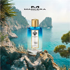 Perfume bottle on a rocky cliff with ocean and mountains in the background