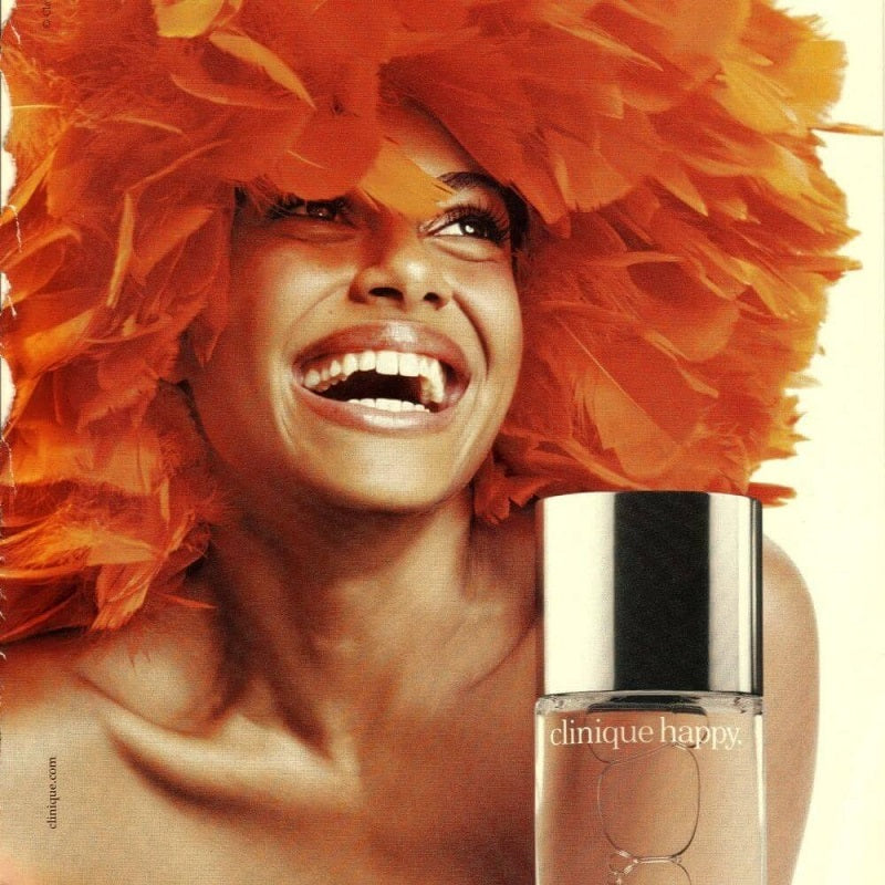 Woman with orange feathers and Clinique Happy perfume bottle