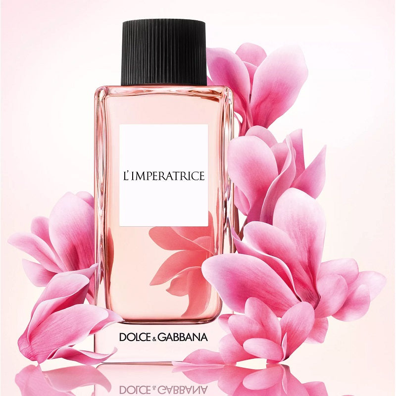 Dolce & Gabbana L'Imperatrice perfume bottle surrounded by pink flowers on a white background