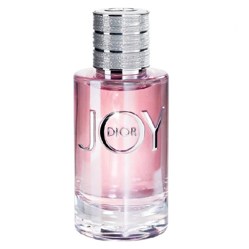 A glass bottle of Dior Joy Eau de Parfum with a pink liquid visible and the brand name 'Dior' inscribed on the bottle.