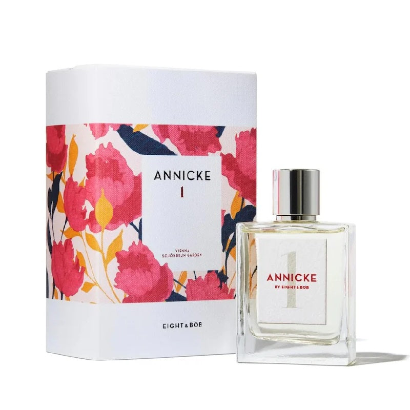 Perfume bottle and packaging with floral design on a white background