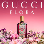 Gucci Flora perfume bottle surrounded by flowers on a pink background