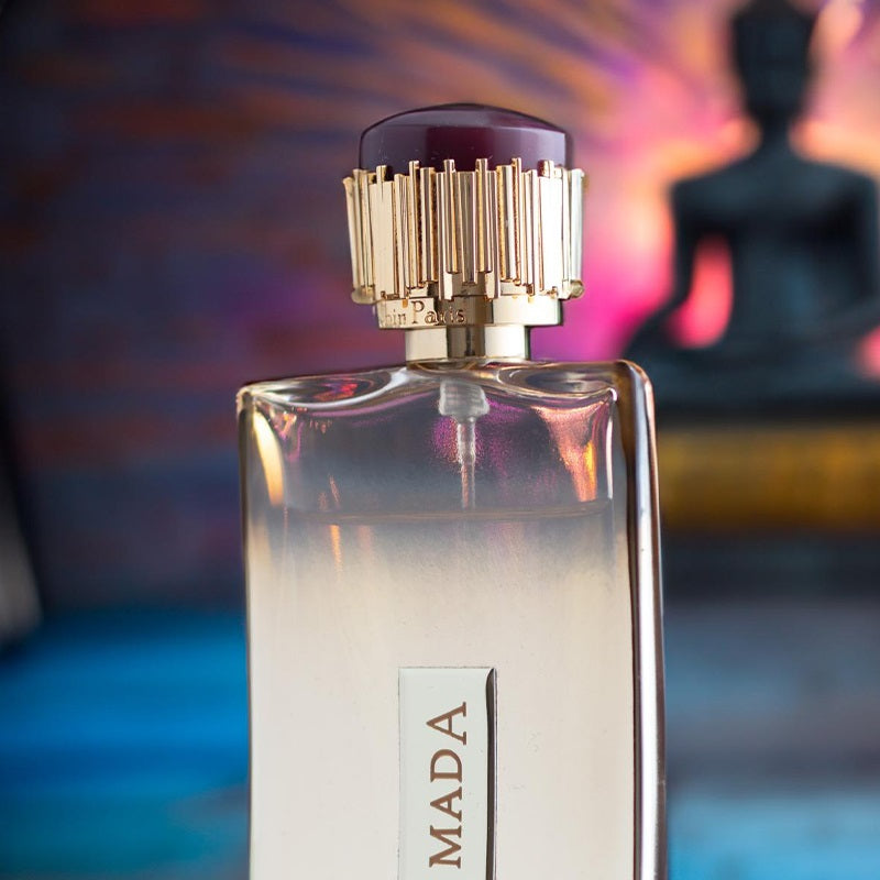Perfume bottle with gold cap against a colorful blurred background
