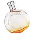 Hermes Eau Des Merveilles eau de toilette bottle with a clear to amber gradient and a silver cap.