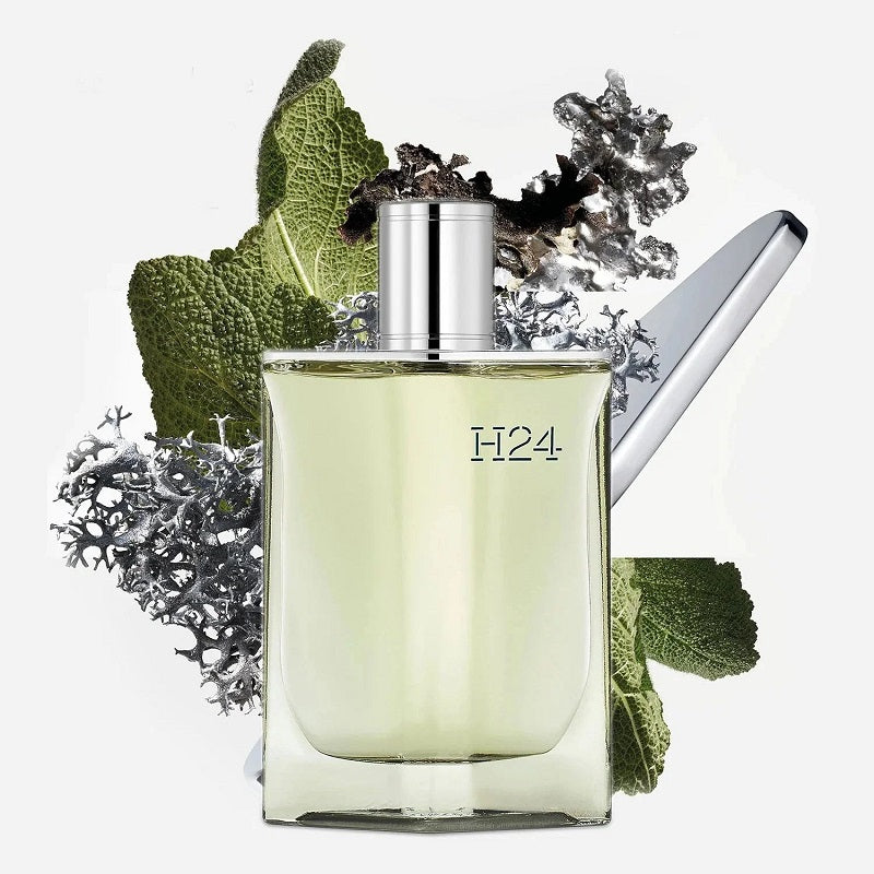 Perfume bottle with green leaves and flowers on a white background
