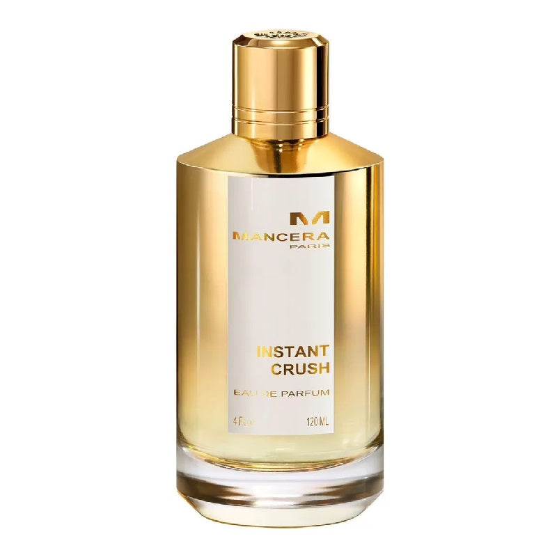 A bottle of Instant Crush Eau de Parfum by Mancera with a gold-colored cap and a clear, amber-colored liquid visible inside the bottle.