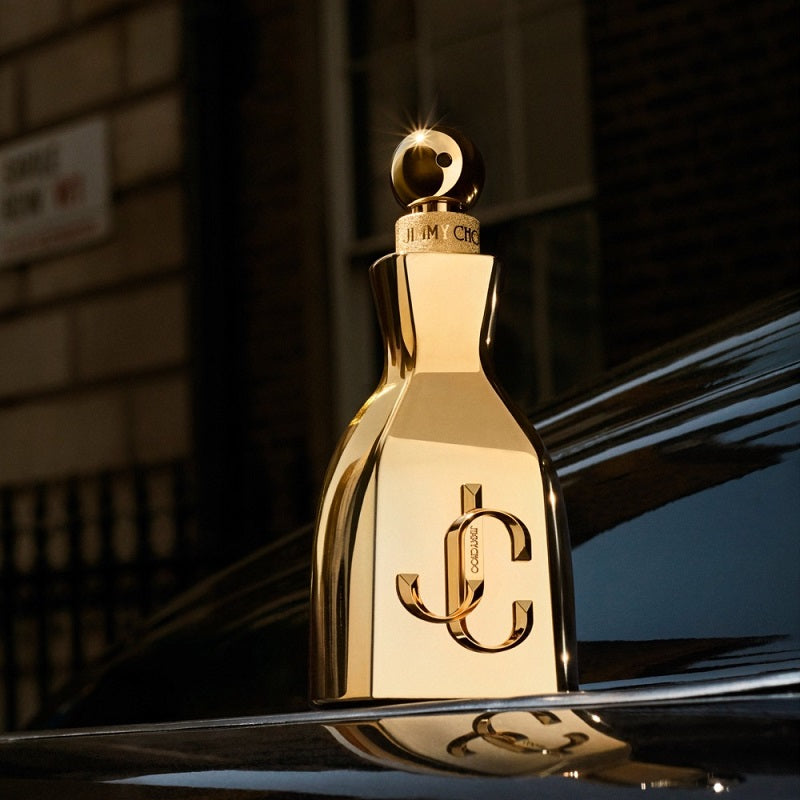 Gold bottle with a logo on a reflective surface