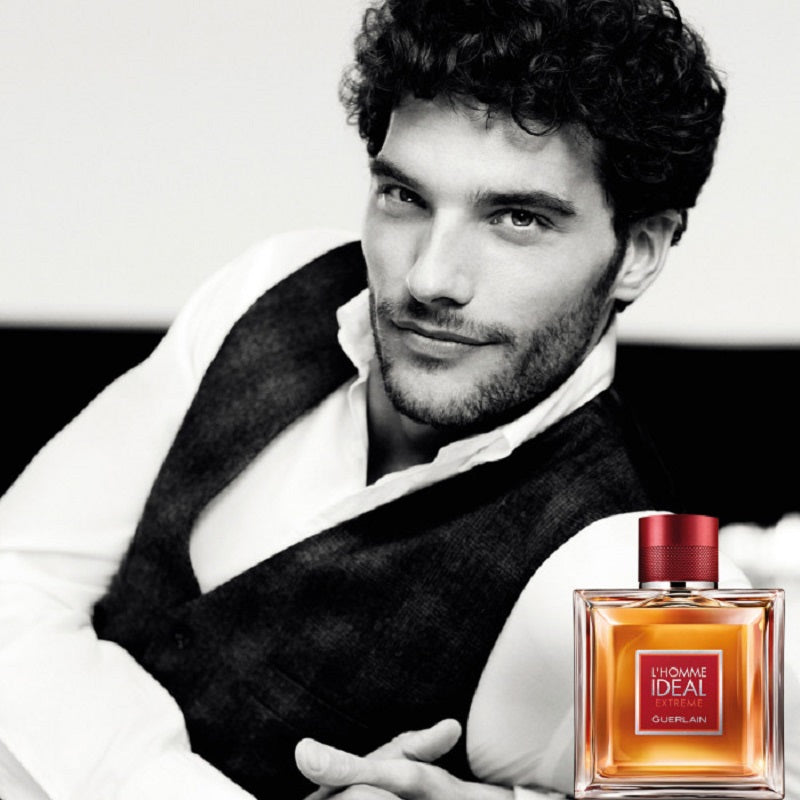 Man in dark vest and white shirt with a perfume bottle