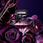 Perfume bottle with purple flowers on a dark background
