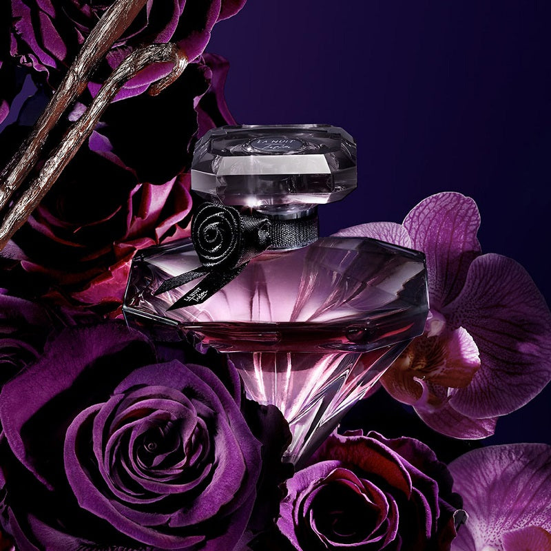 Perfume bottle with purple flowers on a dark background