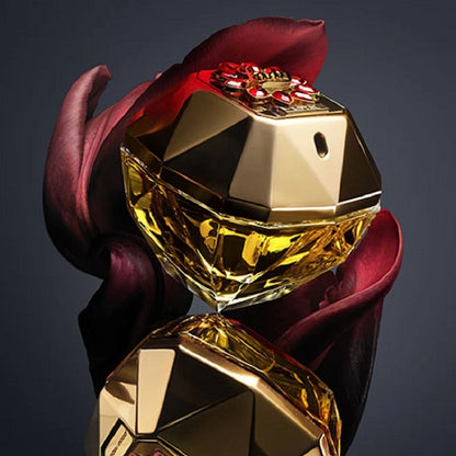 Gold perfume bottle with a red flower on a dark background