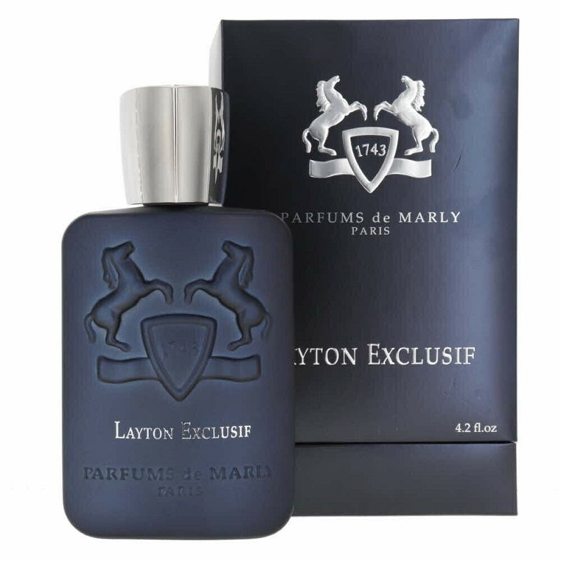 A bottle of Layton Exclusif Eau de Parfum by Parfums De Marly, with a distinctive blue color and silver cap, alongside its packaging box.