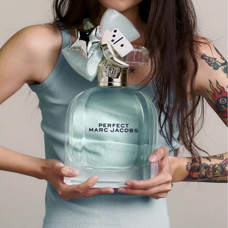 Person holding a large bottle of Marc Jacobs Perfect perfume.