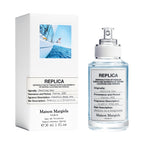 Maison Margiela Replica perfume bottle and its packaging box on a white background.