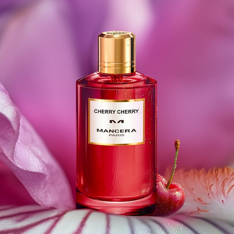 Red perfume bottle with gold cap labeled 'Cherry Cherry' by Mancera Paris, with a cherry and floral background.