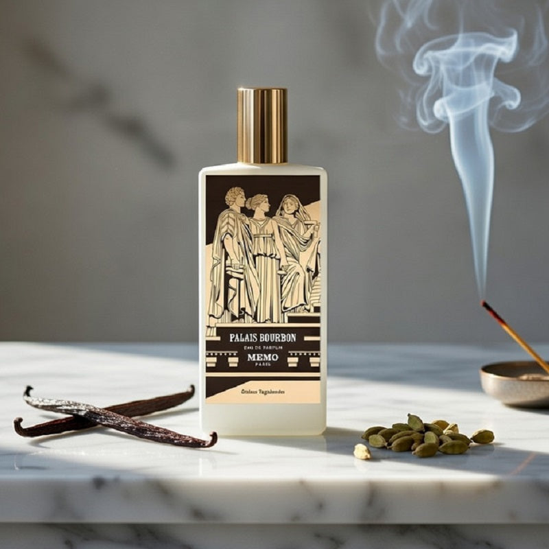 Perfume bottle with decorative label on a marble surface with vanilla bean and cardamom seeds.