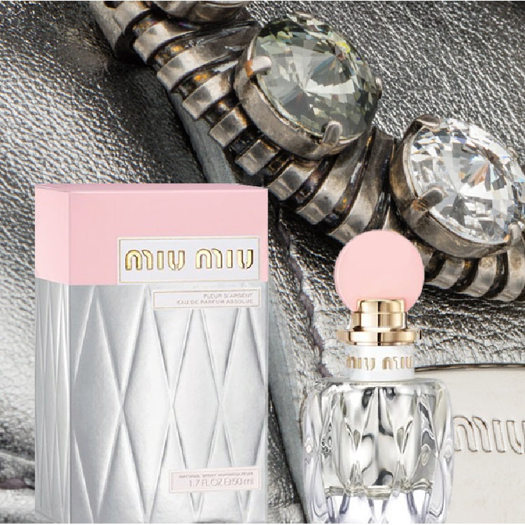 Miu Miu perfume bottle and packaging on a textured background