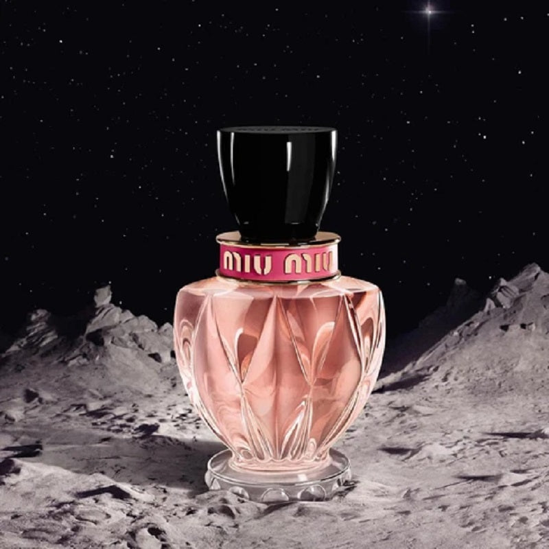 Miu Miu perfume bottle on a moon-like surface with a starry night sky.
