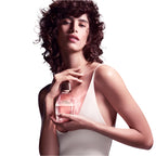 Woman holding a perfume bottle with a white background