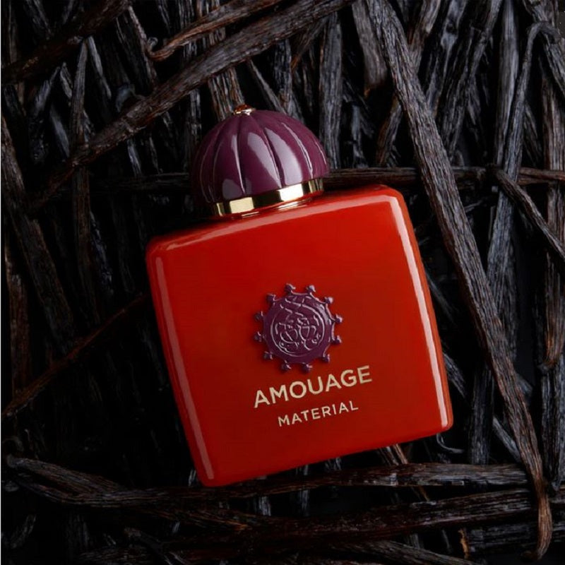 Red Amouage perfume bottle with purple cap on a dark background