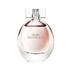 A bottle of Calvin Klein Sheer Beauty Eau de Toilette with a clear, round design and a bow detail on the cap.