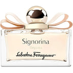 A bottle of Signorina Eleganza Eau de Parfum by Salvatore Ferragamo with a clear, elegant design and a beige ribbon around the top.