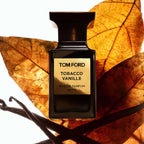 Tom Ford Tobacco Vanille perfume bottle with vanilla beans and leaves on a white background