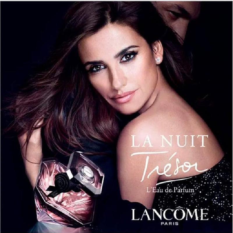 Lancème Tresor perfume advertisement with a model holding the perfume bottle.