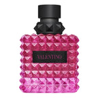 Pink diamond-patterned perfume bottle with black cap on a white background