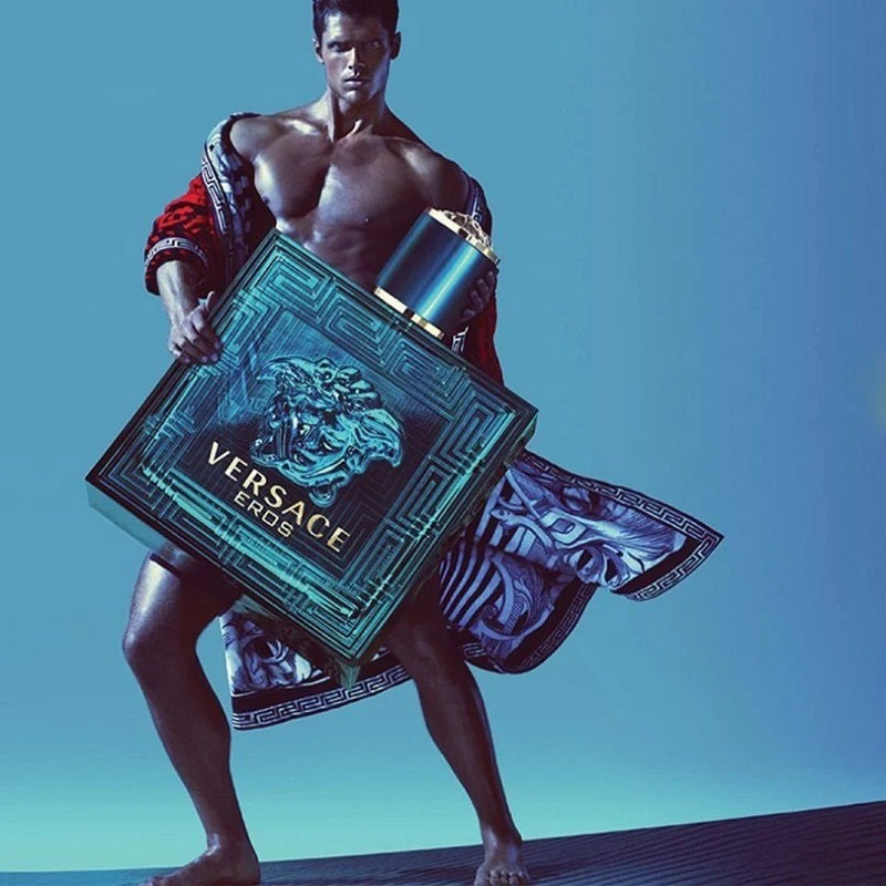 Man holding a Versace box against a blue background