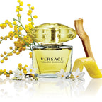Versace Yellow Diamond perfume bottle with yellow flowers and a lemon on a white background