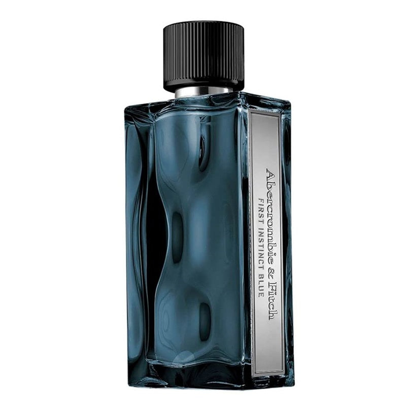 A rectangular glass perfume bottle with a ribbed black cap, filled with deep blue liquid and featuring a vertical silver label that reads 'A Labouche-Crèche & L'Heureux FIRST MISTLEY BLUE'.