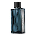 A rectangular glass perfume bottle with a ribbed black cap, filled with deep blue liquid and featuring a vertical silver label that reads 'A Labouche-Crèche & L'Heureux FIRST MISTLEY BLUE'.