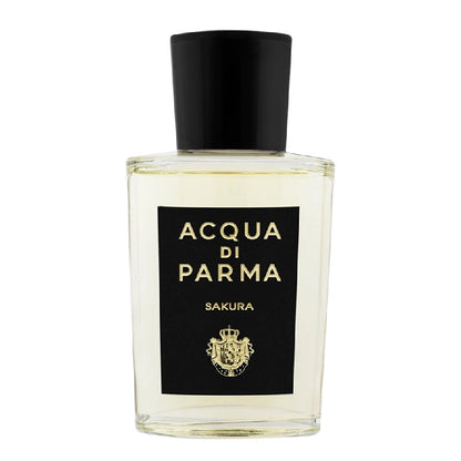 A clear glass bottle of Acqua Di Parma Sakura Eau de Parfum with a black cap and label.