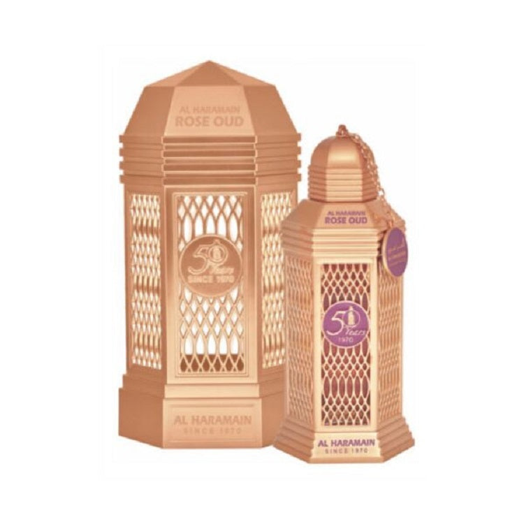 A pink colored bottle of Rose Oud Eau de Parfum by Al Haramain with a decorative cap and label, displayed against a white background.