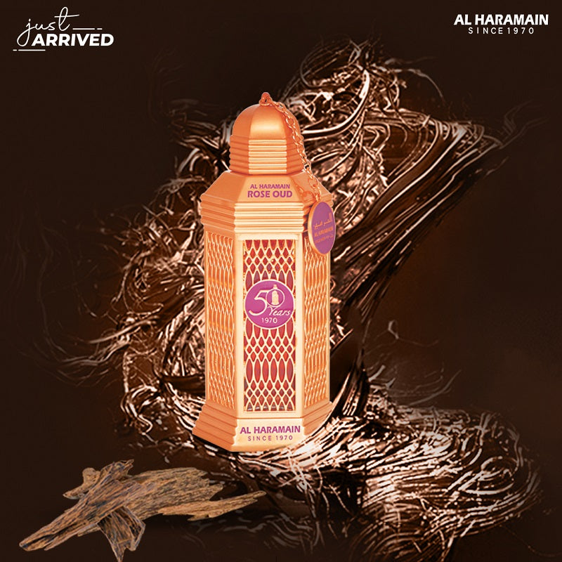 A pink colored bottle of Rose Oud Eau de Parfum by Al Haramain with a decorative cap and label, displayed against a white background.