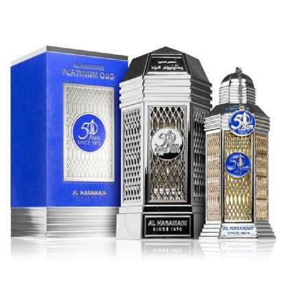 A product image featuring a 100ml Eau de Parfum bottle of Platinum Oud by Al Haramain, with a decorative blue box in the background. The bottle is adorned with a silver cap and a transparent body displaying the amber-colored perfume.